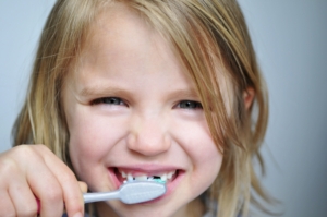 Importance of good dental hygiene – child brushing teeth with parent